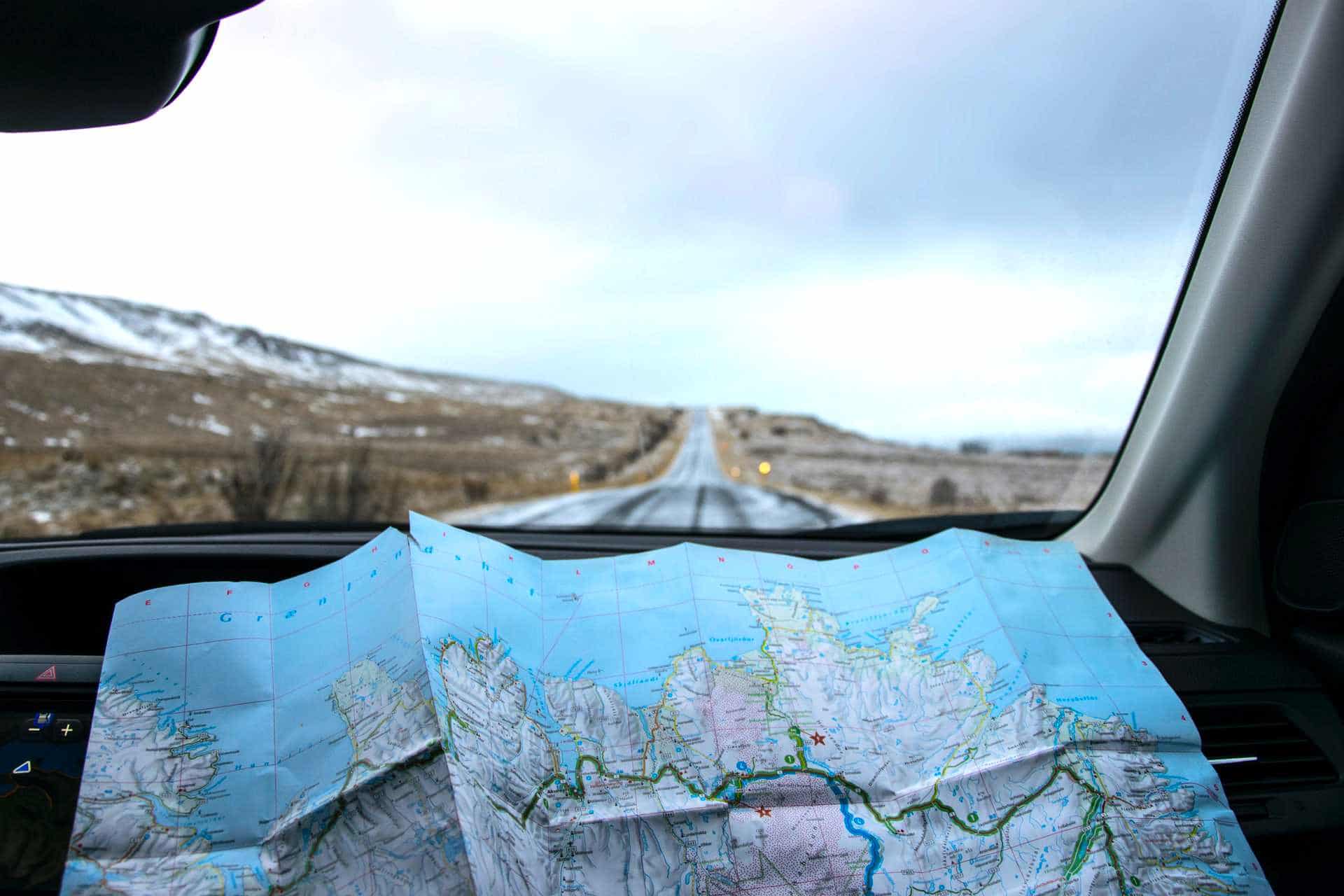River Diver 3 Altitude diver with map of mountain area in hand looking through windshield of a car while driving.