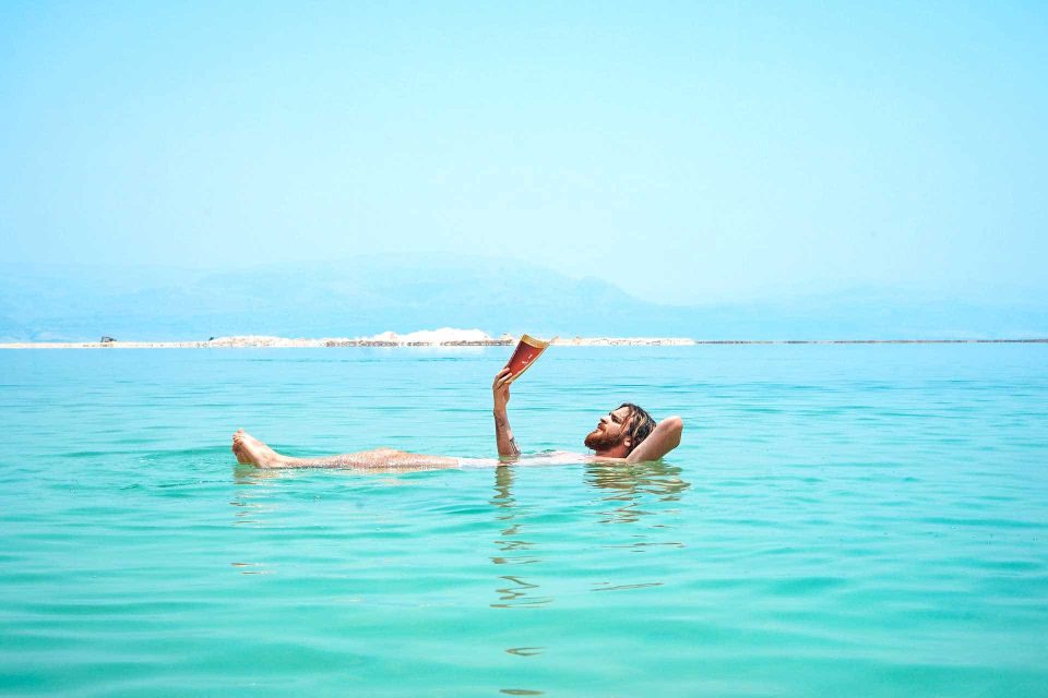 Man reading in Dead Sea floating on surface