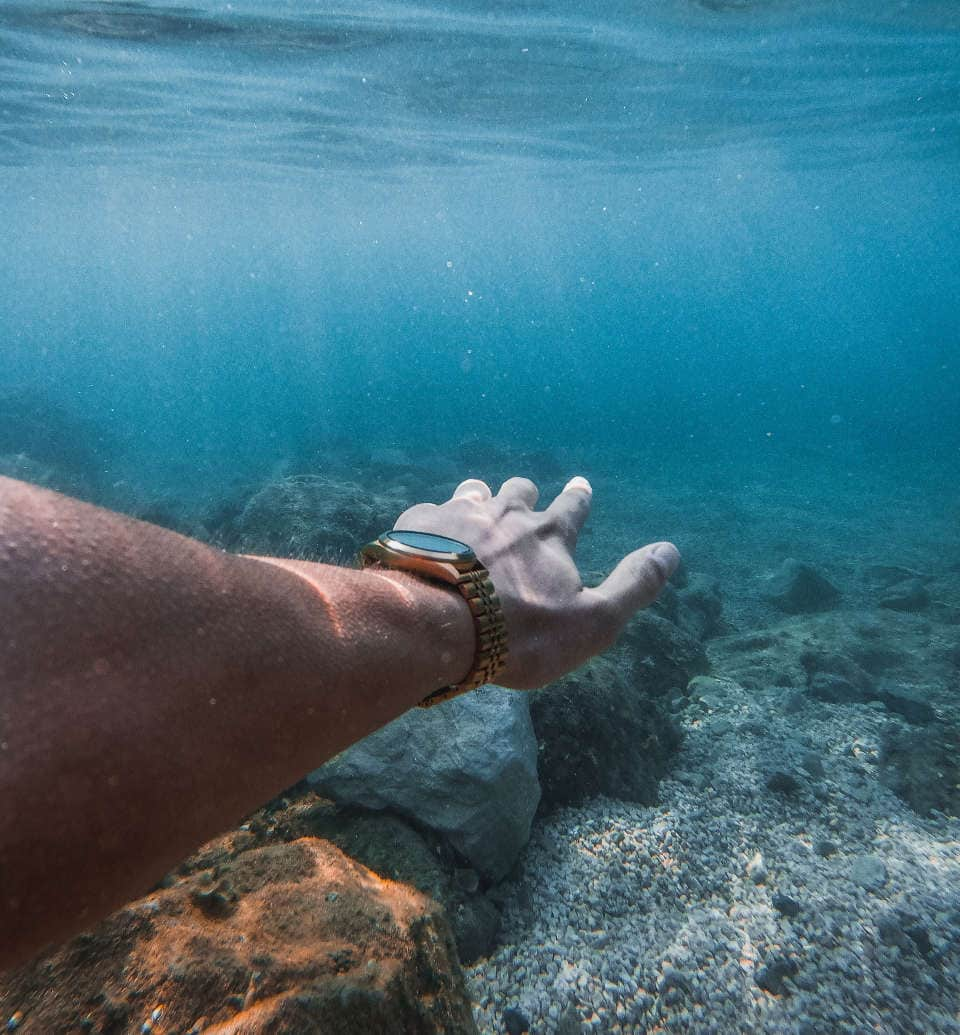 Arm mit Taucheruhr unter Wasser