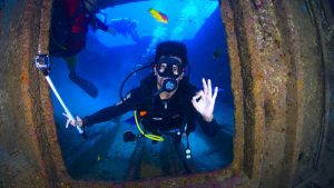 Scuba diver inside wreck with action cam