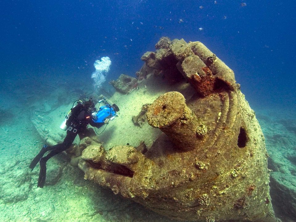Scuba diver filming wreck underwater