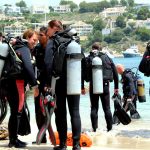 Große Gruppe Taucher am Strand