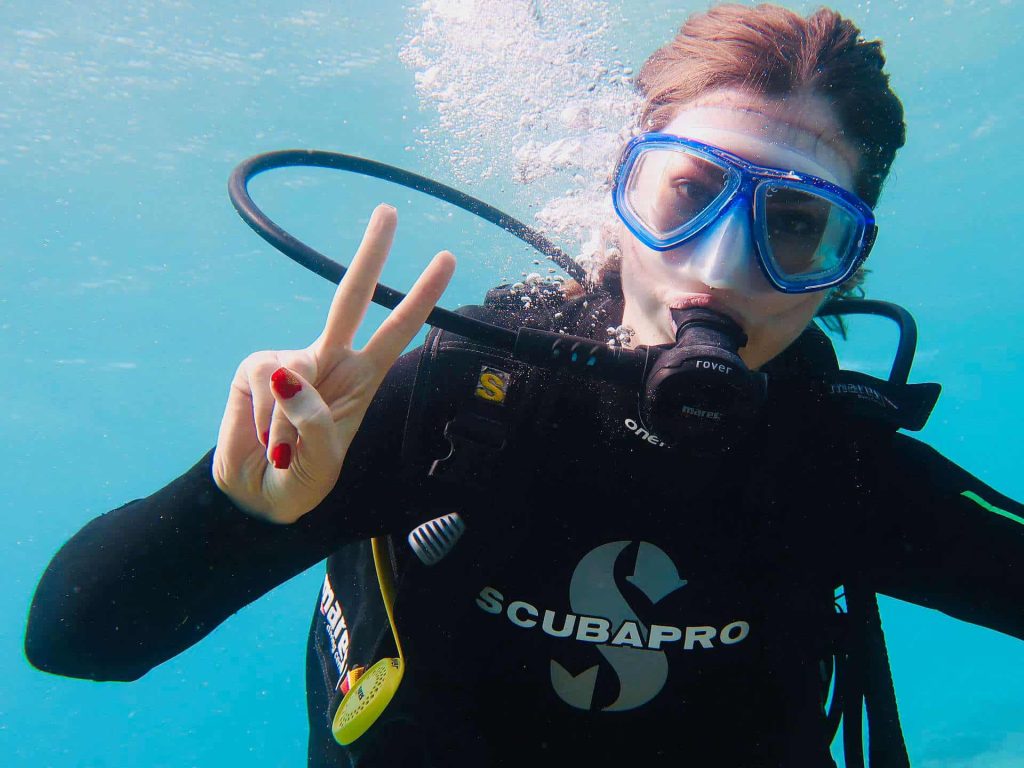 Female scuba diver making victory sign
