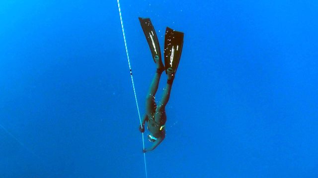 Freediver beim Abstieg an Seil