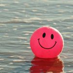 Ball mit fröhlichem Gesicht treibt auf dem Wasser