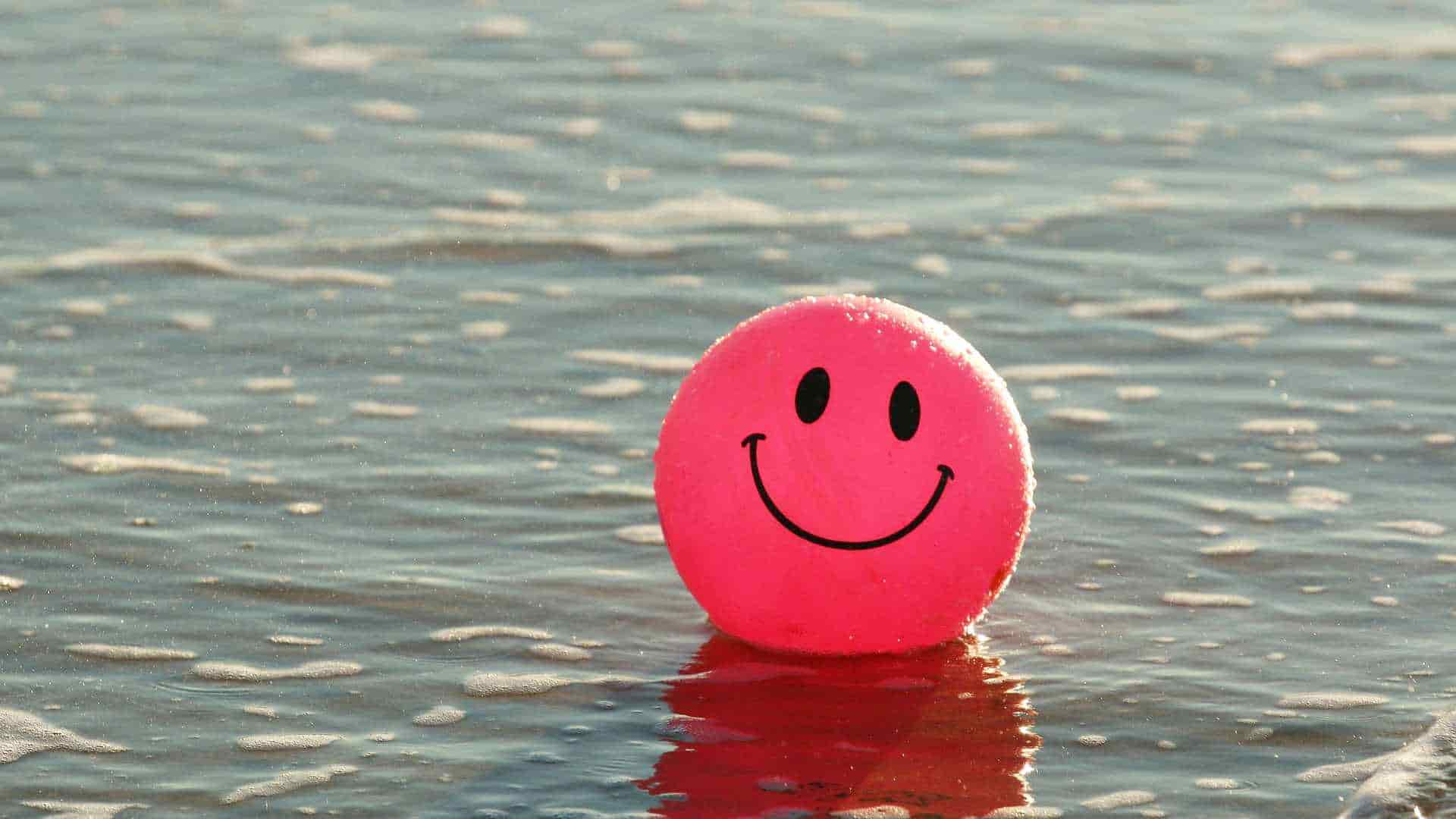 Ball with happy face drawn on it in water