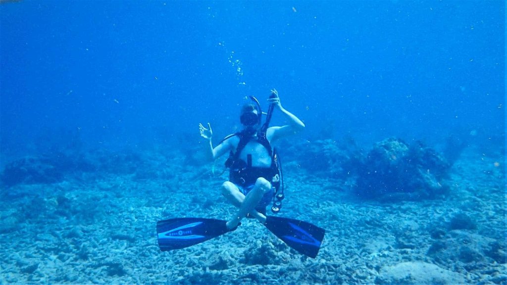 Scuba diver practicing genie seat hovering underwater