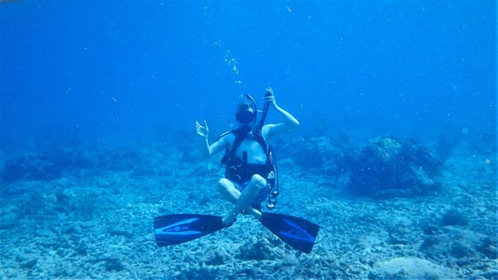 Scuba diver practicing genie seat hovering underwater