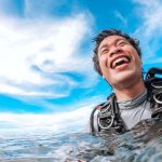 Scuba diver smiling at water surface