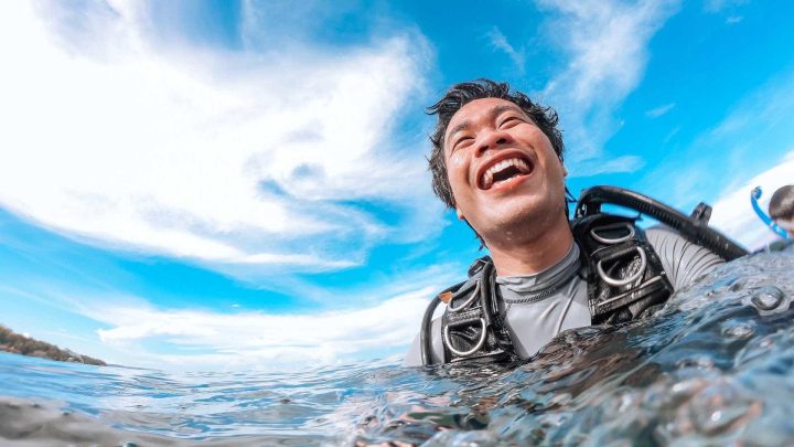 Scuba diver smiling at water surface