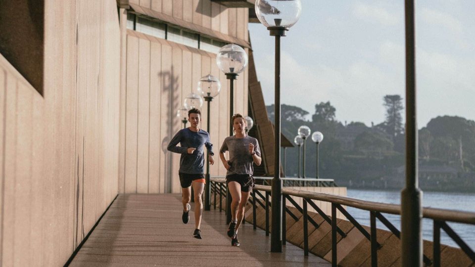 Joggers running along pier