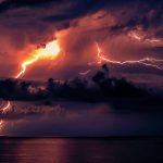Lightning strike over ocean at night