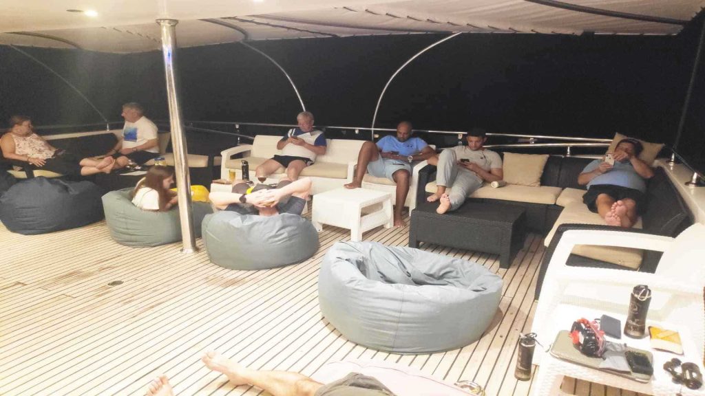 People relaxing on deck of boat after diving