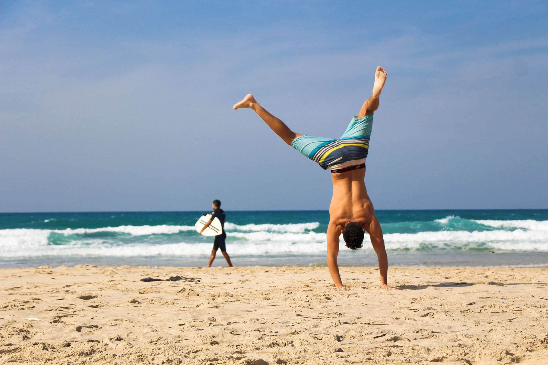 Mann macht Handstand am Strand