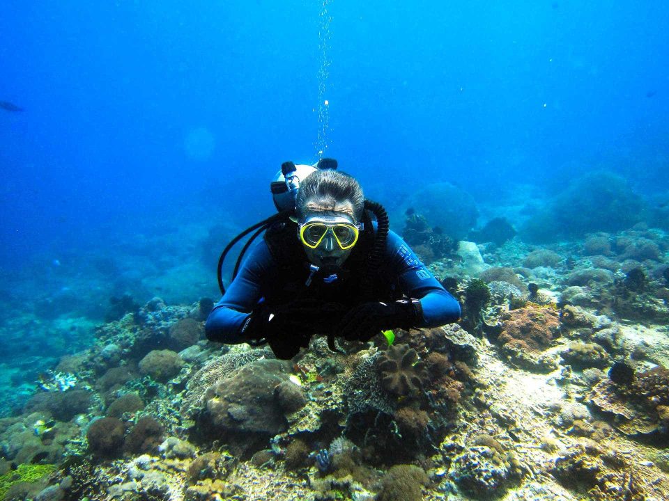 Old scuba diver hovering underwater