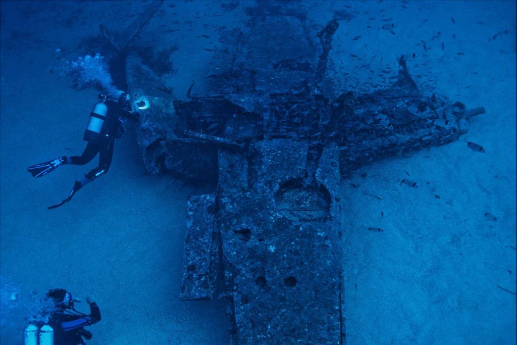 Divers exploring underwater plane wreck