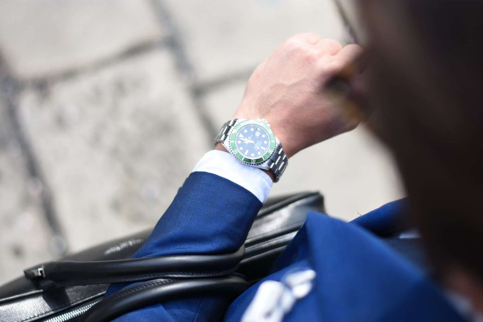 Man in suit wearing Rolex Submariner dive watch