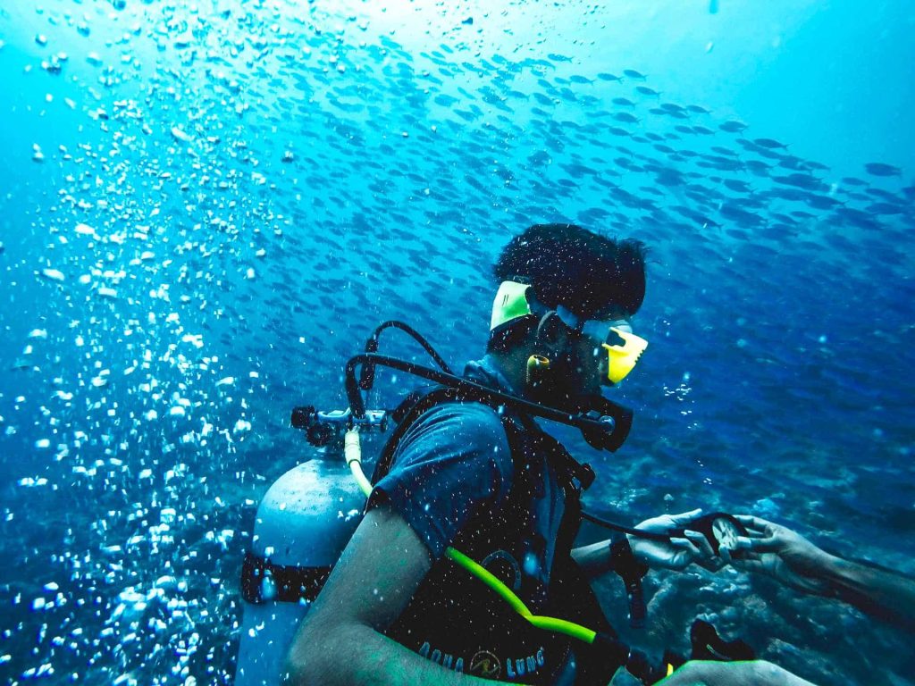 Scuba diver checking pressure underwater
