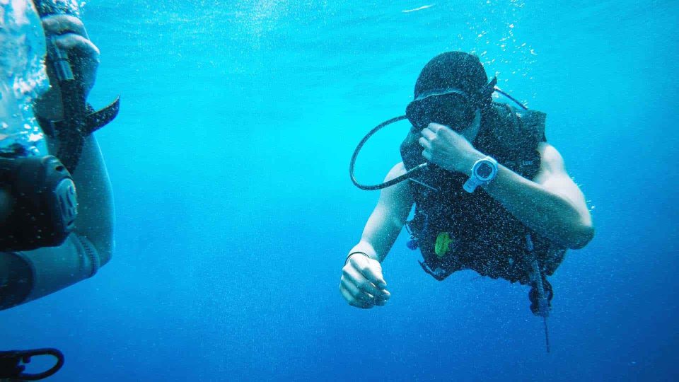 Taucher führt Druckausgleich unter Wasser durch