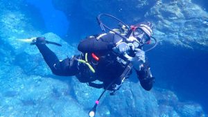 Scuba diver forming heart with gloves hands underwater