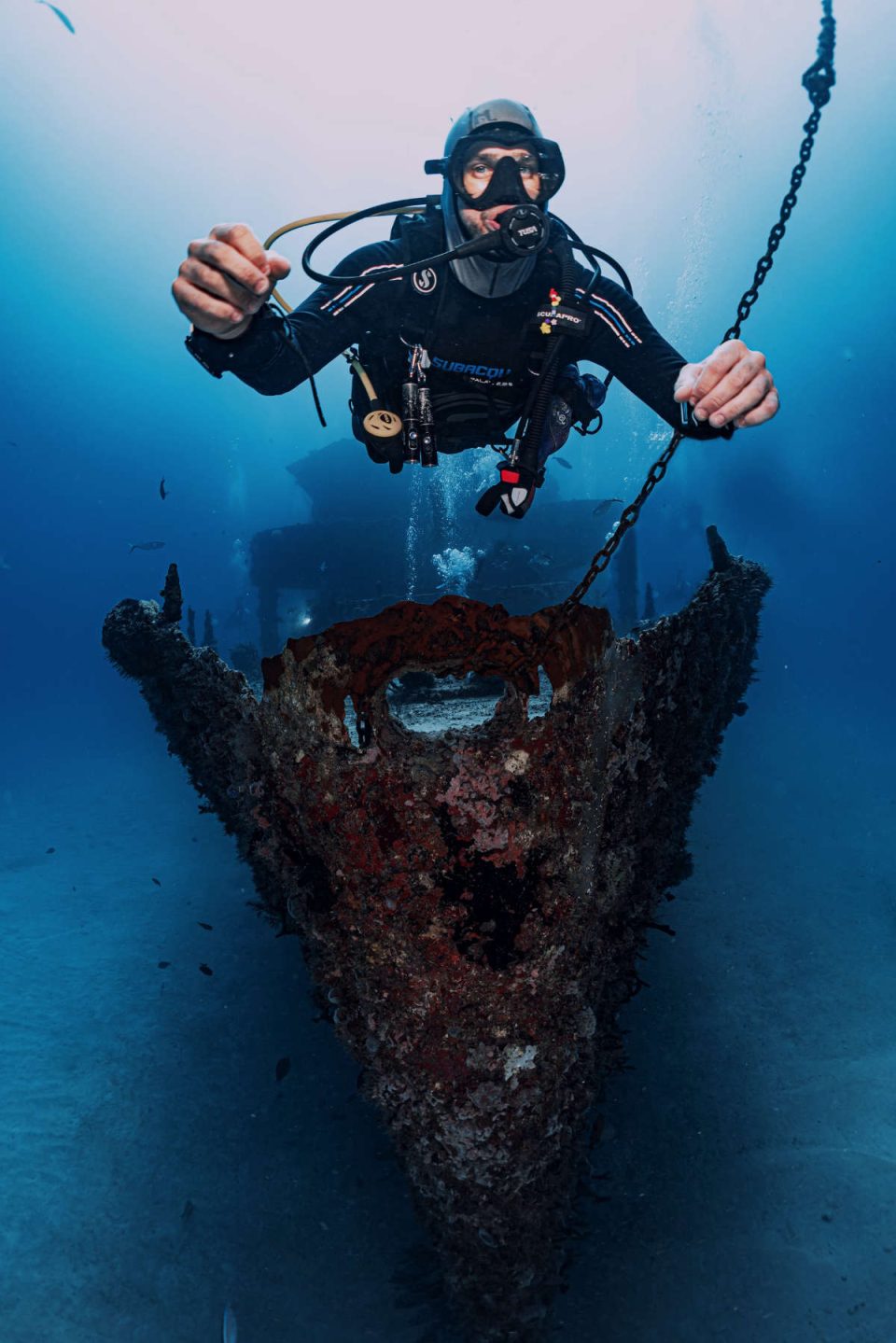 Scuba diver hovering over small wreck