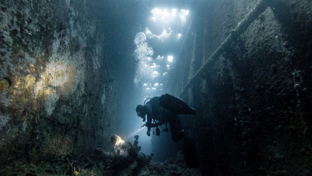 Scuba diver inside wreck at Chuck Lagoon