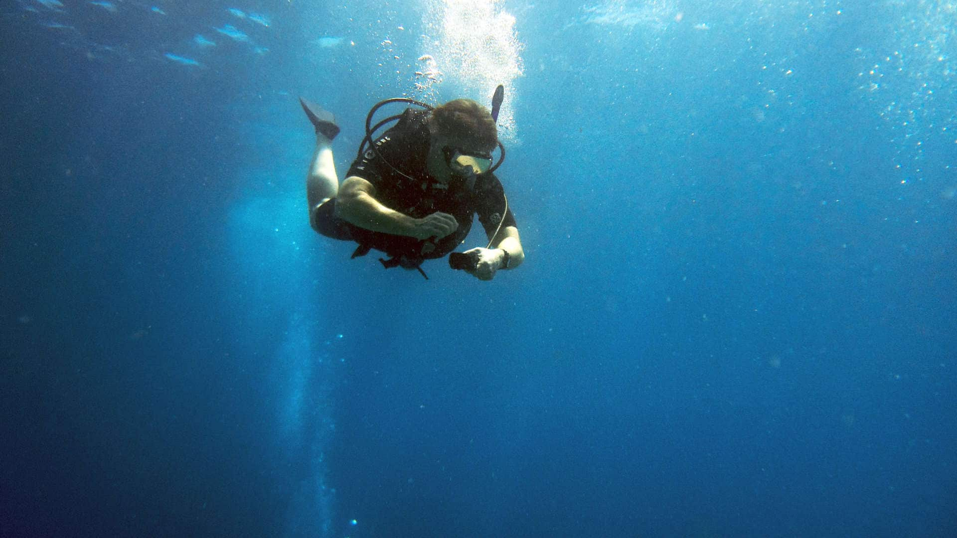 Taucher prüft Druck unter Wasser