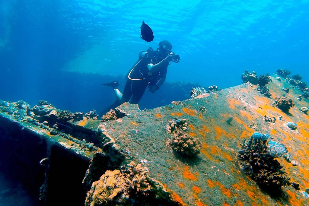 Scuba diver photographing wreck
