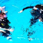 Scuba divers descending in pool