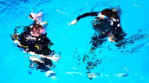 Scuba divers descending in pool