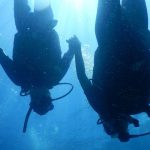 Scuba divers holding hands underwater