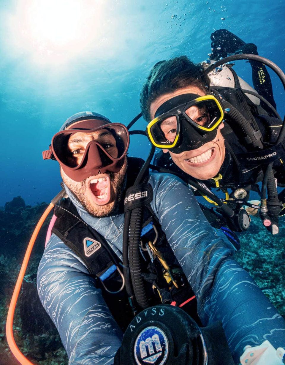 Scuba divers smile into camera