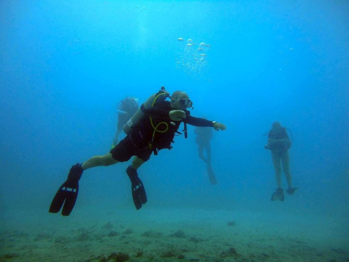 Scuba instructor demonstrating skills underwater