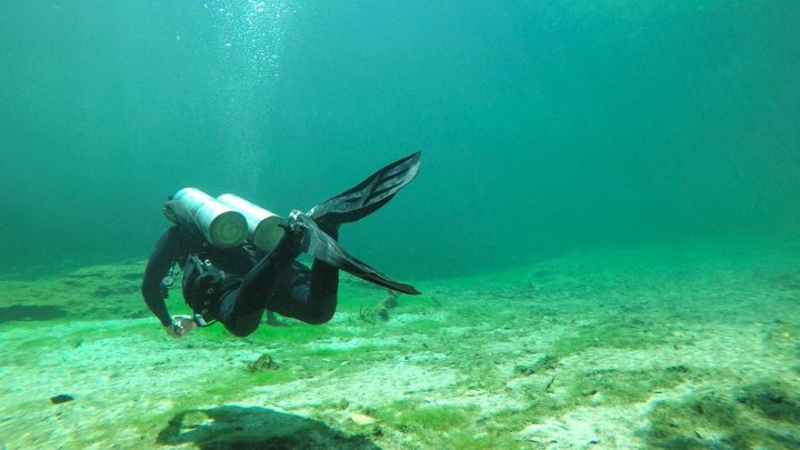Tech diver in lake using flutter kick