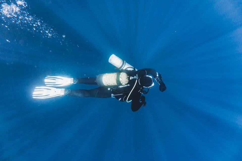 Tech diver checking dive computer underwater
