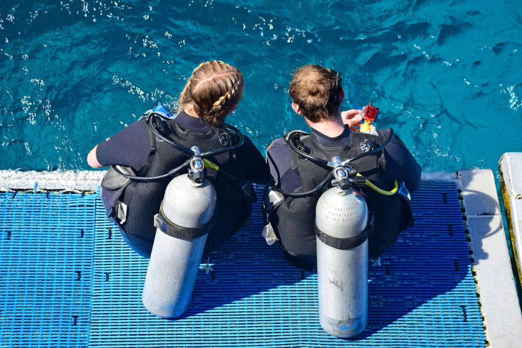 Two divers sitting on plattform