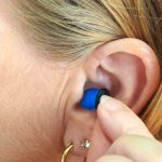 Woman putting earplug into ear