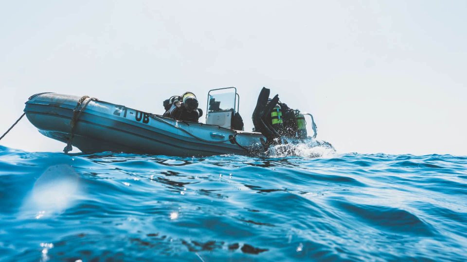 Scuba divers doing backroll to enter water